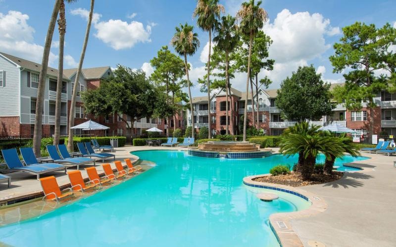 a pool with lounge chairs around it